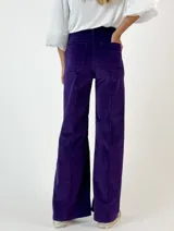 Pantalón de pana lisa color violeta, de corte ancho y suave al tacto.