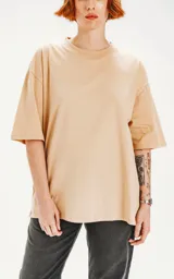 Remera color beige de corte crop y calce oversize, con hombros caídos y cuello redondo.