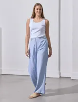 Pantalón celeste a rayas verticales, de lino, corte wide leg y tiro alto con botones decorativos.