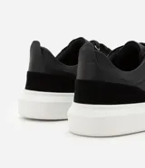 Championes casuales de hombre confeccionados en PU negro con recortes y suela bold blanca.