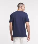 Remera azul marino de corte clásico, confeccionada en algodón más sostenible, con cuello redondo, mangas cortas y estampa de un faro con el texto "light house".