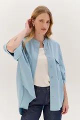 Sobrecamisa celeste de corte recto, con cuello mao, mangas 3/4 con puños y cierre frontal con botones. Tiene dos bolsillos de parche en el pecho.