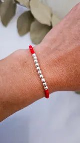 Pulsera roja ajustable con 10 esferas de plata y cristales checos.