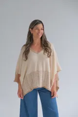 Poncho de tejido de punto color beige con guarda calada en el ruedo.