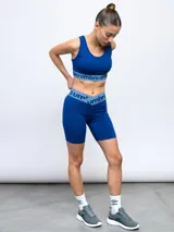 Calza corta de lycra negra con cintura alta y logo de la marca estampado en gris.