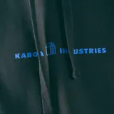 Canguro negro con capucha y bolsillo delantero tipo canguro. Estampado pequeño en el pecho con el logo de la marca en color celeste.