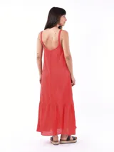 Vestido largo color crudo, con breteles finos y volados en el ruedo.