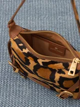 Mini cartera bandolera de cuero con estampado animal print, correa regulable de cuero y pelo, y hebillas metálicas.