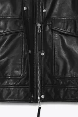 Cazadora bomber de cuero color marrón, con cuello alto, manga larga y bolsillos de parche con solapa en el delantero. Cierre frontal con cremallera metálica y botones a presión ocultos por solapa.