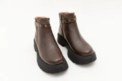 Borcego de cuero negro con plataforma y apliques metálicos.