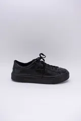 Zapatillas bajas color marrón con textura simil cuero de cocodrilo, cordones al tono y suela de goma blanca con detalle marrón.