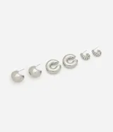 Set de tres pares de aros plateados: un par de argollas con strass, un par de argollas gruesas y un par de aros tipo piercing.