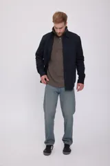 Camisa negra de manga larga con cuello clásico y cierre frontal con botones. Tiene un bolsillo de parche en el pecho izquierdo.