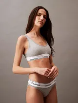 Conjunto Calvin Klein Modern Cotton gris melange, compuesto por corpiño deportivo con breteles anchos y bombacha clásica. Ambos con banda elástica blanca con logo de la marca.