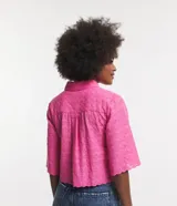 Camisa corta color rosa con textura de flores, escote camisero, manga corta, abotonado frontal y bajo con recorte ondulado.