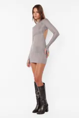 Vestido corto color marrón con brillos, de tejido de punto satinado, mangas largas con mitones en los puños, cuello semipolera y espalda descubierta con elástico.