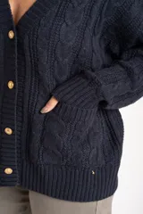 Cardigan de punto trenzado color azul marino, con escote en V, botones dorados y bolsillos delanteros.