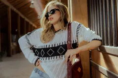 Sweater de punto calado color blanco con detalles geométricos en negro.