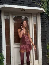 Vestido corto con lentejuelas color verde esmeralda, escote en V profundo y espalda descubierta.