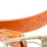 Cinturón color naranja de cuero vacuno con estampado de flores y hebilla metálica con detalle de flores.