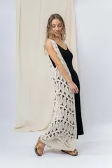 Chaleco largo tejido en punto calado color beige, de silueta recta y caída fluida. Presenta un diseño artesanal con transparencias sutiles que aportan textura y movimiento.