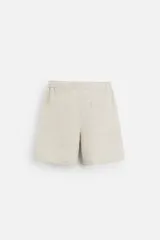 Bermuda regular fit negra confeccionada en tejido de lino. Cintura elástica ajustable con cordón y pliegues frontales. Bolsillos frontales y detalle de bolsillos traseros de plastrón.