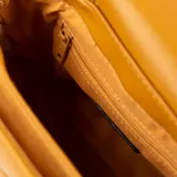 Cartera bandolera color suela, con solapa y diseño acolchado en símil cuero. Tiene un bolsillo interno con cierre, un bolsillo externo abierto, correa regulable y asa fija.