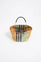 Bolso de mano mini con estructura rígida y diseño a rayas horizontales en tonos amarillo, naranja, verde, gris y negro. Tiene asa de mano negra, asa de hombro de cuero marrón regulable, etiqueta con logo Bimba y Lola, acabados metálicos y cierre magnético. Incluye bolsillo interior.