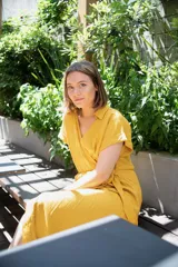 Vestido negro de lino con cuello y manga corta, corte a la cintura con lazo ajustable.