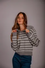 Sweater de punto color beige con rayas horizontales blancas, cuello polo con cierre de cremallera y mangas largas.