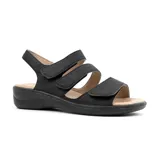 Sandalias bajas de cuero sintético color negro, con tres tiras horizontales con velcro y tira trasera con hebilla.