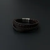 Pulsera de cuero marrón con múltiples tiras, algunas trenzadas y otras lisas, unidas por un cierre metálico plateado.
