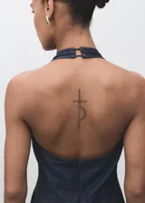 Mono largo de denim azul oscuro, sin mangas, con cuello halter y escote en la espalda. Presenta un corte recto y holgado en las piernas.