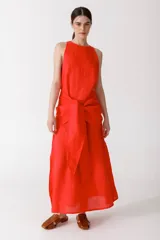 Vestido largo color rojo, sin mangas, con cuello redondo y lazo a la cintura.