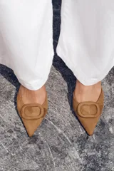 Zapato destalonado color marrón de tejido suave, con punta fina, tacón fino y tira trasera ajustable.