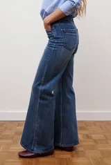 Jean de corte semi oxford con tiro alto, confeccionado en denim azul oscuro con costuras a la vista y bolsillos funcionales.