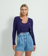 Cardigan cropped de punto color azul marino, con cuello redondo, punto texturizado y cierre frontal con botones contrastantes.