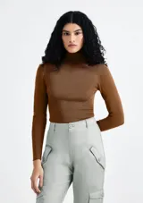 Blusa de manga larga ajustada, color marrón, con cuello alto y tejido acanalado.