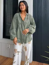 Camisa verde con bordado floral, corte suelto y mangas abullonadas.