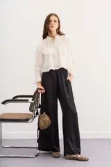 Pantalón palazzo negro de tiro alto con cintura elastizada y bolsillos diagonales.