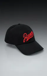 Gorra negra de gabardina con bordado rojo de la palabra "Ravers" en letra cursiva. Tiene cinta trasera de velcro para regular el ajuste.
