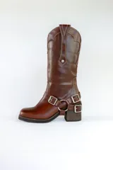 Bota de cuero marrón con caña alta, taco de madera y arnés con hebillas metálicas.