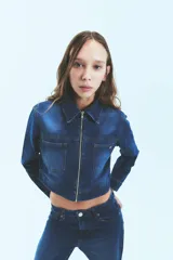 Campera de denim azul con cierre metálico, bolsillos delanteros y diseño de silueta caja.