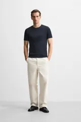 Camiseta slim fit de cuello redondo y manga corta, confeccionada en tejido de algodón con elasticidad.