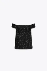 Top chaleco negro con escote recto y hombros descubiertos, con lentejuelas a tono y aberturas laterales.