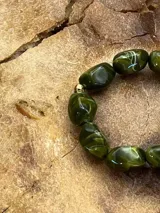 Set de pulseras elásticas con cuentas de piedra en tonos amarillo, naranja, rojo, verde y marrón.