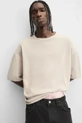 Camiseta color gris verdoso de punto tejido en hilatura de algodón, con cuello redondo, manga corta, efecto lavado y acabados irregulares.