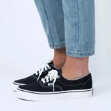 Championes Vans Era negros con costuras blancas y suela blanca.