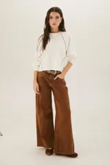 Pantalón de jean acampanado color caramelo con cintura alta y cinturón marrón con tachas.