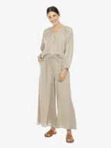 Conjunto de camisa y pantalón a rayas verticales en tonos beige, gris y amarillo. La camisa es de manga larga con cuello bote y botones en el frente. El pantalón es de corte palazzo con cintura elastizada y lazo ajustable.